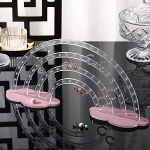 Rainbow acrylic earring display stand with cloud base on a reflective surface
