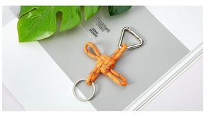 Macro detail of an orange reflective braided paracord keychain with a metal carabiner clip