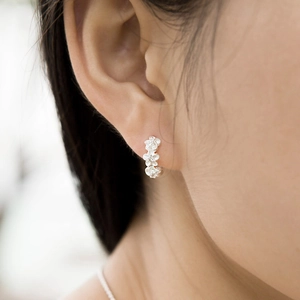 Boucles d'oreilles fleur camélia en argent avec zircon portées par un mannequin