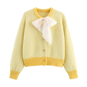 Chic yellow knit cardigan featuring a white chiffon bow and gold embossed buttons