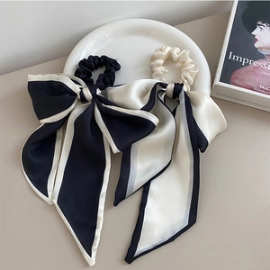 Set di elastici per capelli in raso bianco e nero con nastri lunghi su piatto decorativo