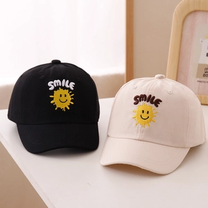 Detail of smile face embroidery on cotton baseball caps in black and beige