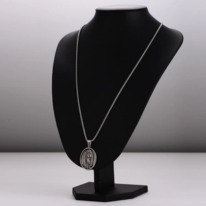 Vintage silver Guadalupe Virgin Mary pendant necklace displayed on a black mannequin bust