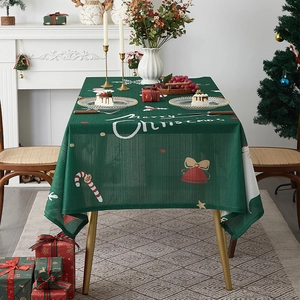Detailed view of green fabric Christmas tablecloth with Merry Christmas text and festive patterns