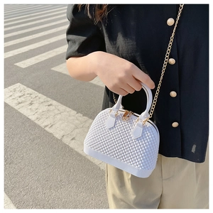 Detail of white PVC shell bag with bubble texture and golden chain strap for women