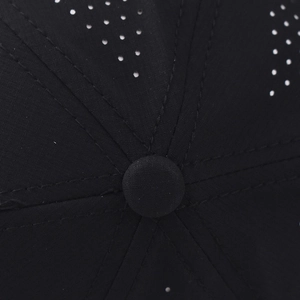 Dettaglio macro dei fori di ventilazione laser sul cappellino sportivo nero traspirante