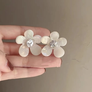 Detailed view of french vintage floral pearl stud earrings with zircon center inlay