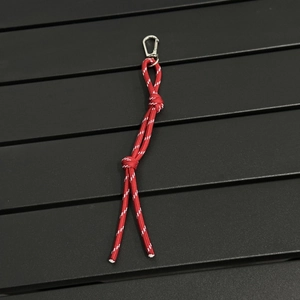 Detail shot of a red hand-woven keychain rope with a metallic climbing carabiner hook