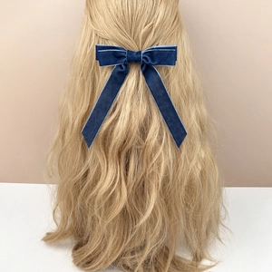 Elegant navy blue velvet bow hair clip with long ribbons on blonde wavy hair