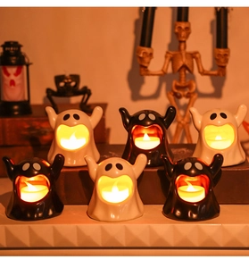 Macro detail of Halloween ghost LED candle holders in black and white ceramic finish