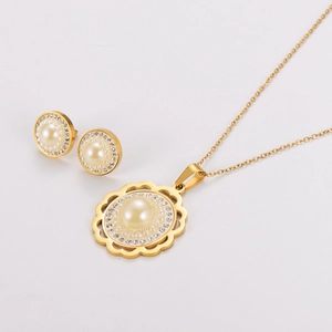 Detail of gold flower necklace and earrings set with central pearls and zircon halo