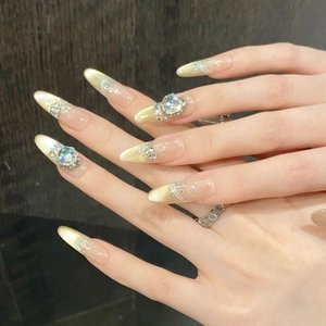 Golden cat-eye press-on nails with luxury crystals and gradient shimmer on almond shape