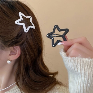 Close-up of star-shaped hair clips in black and white polka dots on model hair