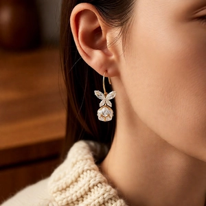 Gros plan de boucles d'oreilles papillon dorées avec cristaux brillants sur un mannequin