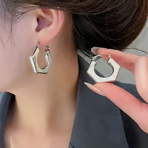 Minimalist silver hexagonal geometric hoop earrings with a polished mirror finish for women