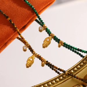 Detail of 18K gold-plated Fatima Hand pendant with tiger eye and malachite beads