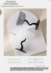 Detail view of tall glass ice cream bowls with creative black wavy handles in cream and grey