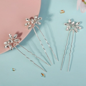Gros plan sur trois épingles à cheveux en U argentées avec motifs de fleurs en strass