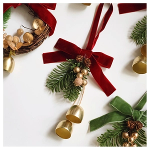 Macro detail of Christmas bells with velvet bows, pine cones and artificial pine needles