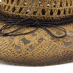 Macro detail of hand-woven straw cowboy hat with diamond hollow pattern and bow tie
