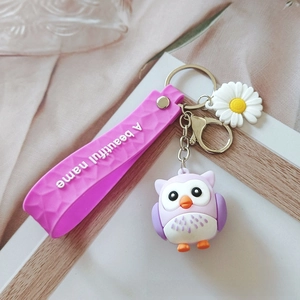 Detailed view of a purple owl keychain with silicone strap and daisy floral charm