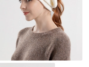 Close-up of soft white knit beanie texture and warm brown knit sweater collar detail