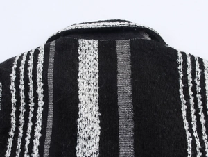 Close-up of the black and white striped woven fabric texture on the coat shoulder