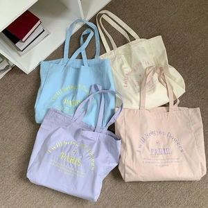 Detailed display of four colorful canvas tote bags with Paris floral embroidery