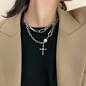 Détail macro du collier double rang en argent avec pendentif croix, strass et perles