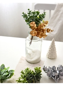 Artificial eucalyptus sprigs in a reindeer glass vase for Christmas home decor