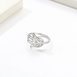 Silver stainless steel Hamsa hand ring featuring intricate hollow design on white surface