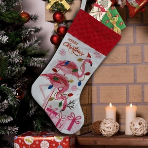 Close-up of white plush Christmas stocking with pink flamingo and festive patterns