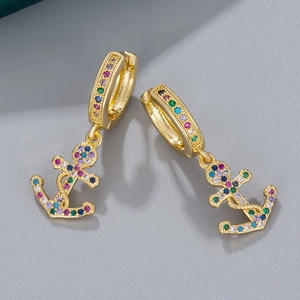 Elegant gold anchor earrings with colorful rhinestones set against a neutral grey background