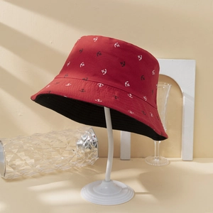 Red reversible bucket hat with white anchor patterns and black lining for sun protection