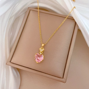 Detailed shot of pink heart zircon pendant with crystal accents on a gold necklace