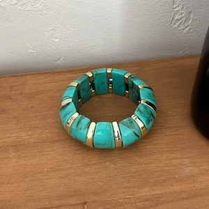 Détail macro du bracelet en résine marbrée turquoise avec entretoises en métal doré
