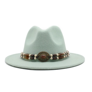 Detail of mint green fedora hat featuring ethnic beaded band and vintage bronze gemstone