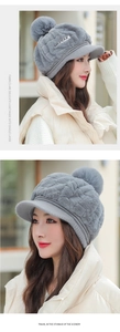Detail of grey plush winter earflap hat with fluffy pom pom and girlspeak label