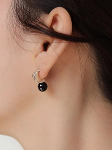 925 silver hoop earring with faceted black bead pendant worn on model's ear