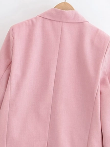 Detail view of the pink blazer back texture on a wooden hanger with clean background