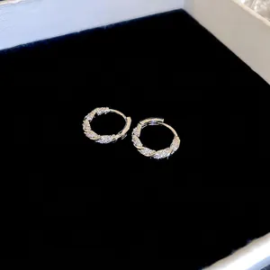 Silver twisted rope hoop earrings with pavé cubic zirconia on black velvet background