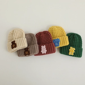 Detailed view of knitted infant hats with cute animal patches in five autumn colors