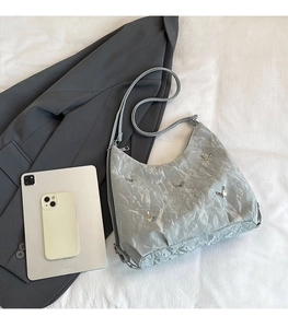 Silver-grey tote bag with butterfly detail shown next to iPad for size comparison