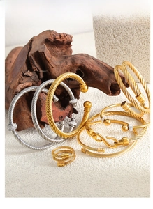Détail de bracelets torsadés avec diamants pavés scintillants sur un fond de roche brute