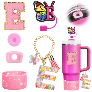 Detail view of pink resin letter E charm, glitter boot and butterfly straw cover set