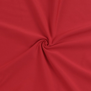 Vue macro du tissu satiné rouge montrant la texture torsadée et le drapé de la robe longue