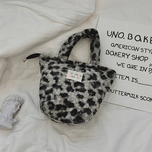 Detail of plush leopard print handbag showing fuzzy texture and colorful woven label