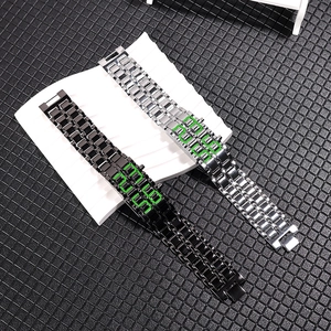 Detail of LED lava wristwatches in black and silver metal bands with green digital display
