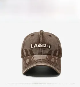 Close-up of brown washed cotton baseball cap with white embroidery and tribal flame patterns