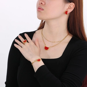 Gold-plated jewelry set with red enamel semi-circles featuring necklaces, rings, and earrings